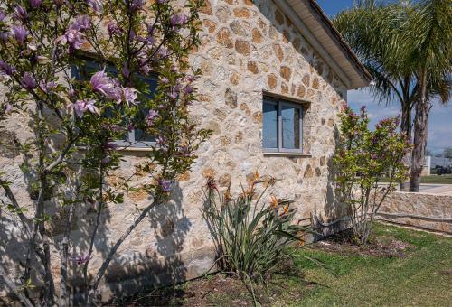 a stone building with windows and flowers in front of it at Villa Manolia in Preveza