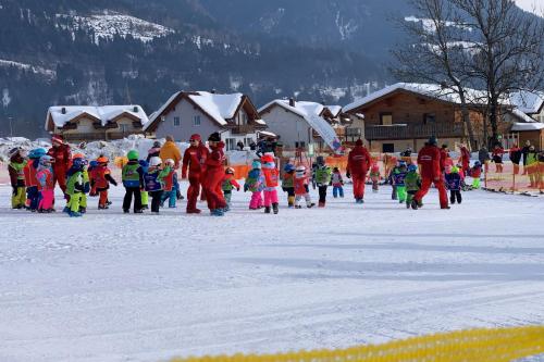 a group of children are walking in the snow at Chalet Giusto in Kötschach
