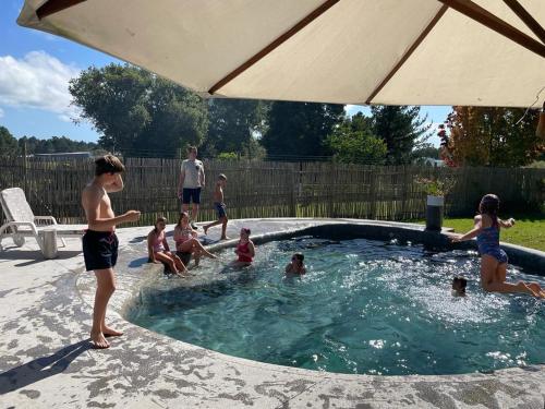 a group of children playing in a swimming pool at Farm House Plettneberg Bay in Plettenberg Bay