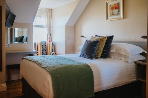 Un dormitorio con una cama grande con almohadas. en Móinéir House, en Kilkee