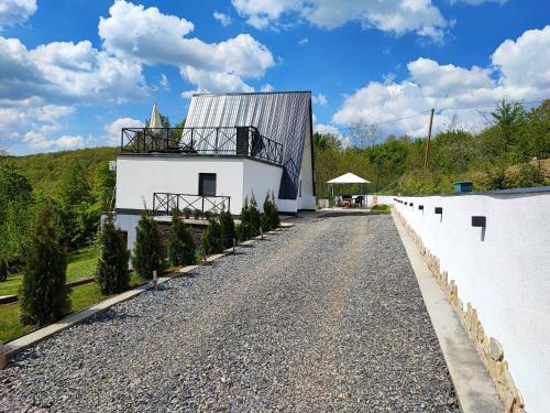 a road leading to a white building with trees on the side at Linden Forest House in LipoviC(244)ka Mehana