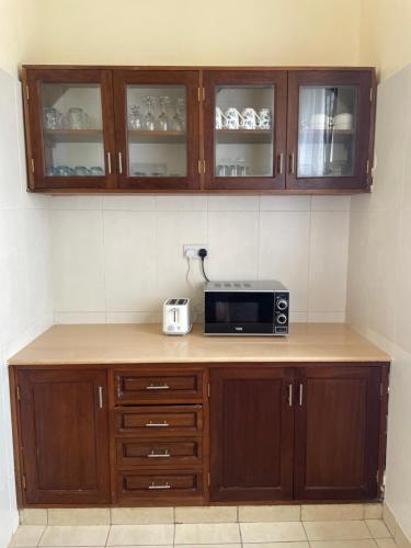 a kitchen with a microwave on a counter at Villa Macheo in Mombasa