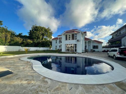 una casa con piscina frente a una casa en Villa Macheo en Mombasa