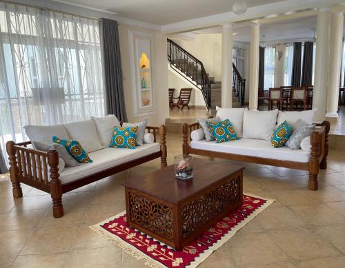 a living room with two couches and a coffee table at Villa Macheo in Mombasa