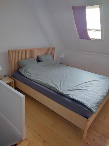 a bed in a white bedroom with a window at 2 1/2 Zimmer Ferienwohnung in Erlach