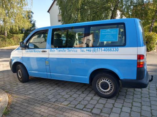 a blue van parked on the side of a street at Airport Park Hotel MUC in Hallbergmoos
