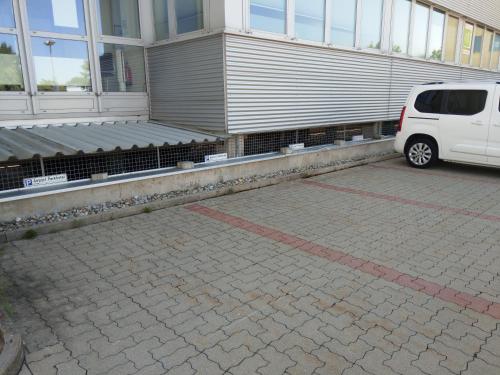 a white van parked in a parking lot next to a building at Airport Park Hotel MUC in Hallbergmoos