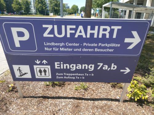 a blue sign for a parking sign in front of a building at Airport Park Hotel MUC in Hallbergmoos