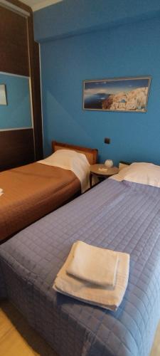 una camera d'albergo con due letti e un asciugamano sul letto di Villa Kazarma a Metókhion