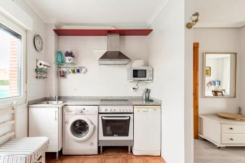 uma cozinha com uma máquina de lavar roupa e um lavatório em La Solana de Boo em Boo de Piélagos