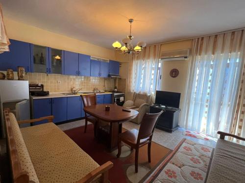 cocina y comedor con armarios azules y mesa en Ervis beach apartment 5 minutes walking apartment-beach ONLY 2 NIGHS ORE MORE, en Durrës
