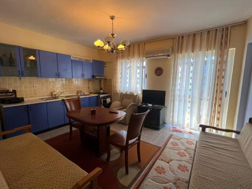 cocina y sala de estar con armarios azules y mesa en Ervis beach apartment 5 minutes walking apartment-beach ONLY 2 NIGHS ORE MORE, en Durrës