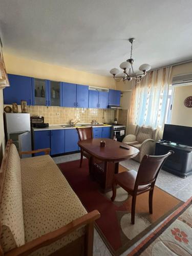 sala de estar con mesa y cocina con armarios azules en Ervis beach apartment 5 minutes walking apartment-beach ONLY 2 NIGHS ORE MORE, en Durrës