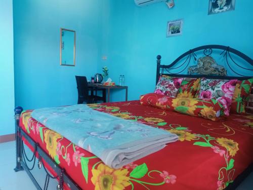 a bedroom with a bed with a red and colorful blanket at Cowang Dereng Home Stay in Labuan Bajo