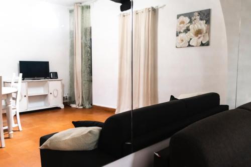 sala de estar con sofá negro y mesa en La casa di Gioia, en Ostia Antica
