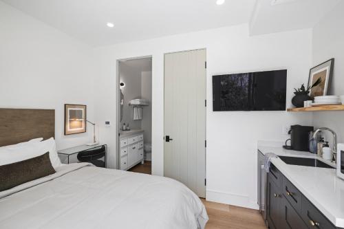 um quarto branco com uma cama e um lavatório em Casa Jardin - Boutique Suites in Downtown Santa Barbara em Santa Bárbara