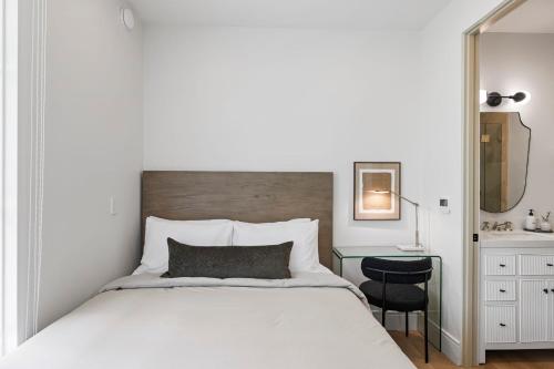 a bedroom with a bed with a desk and a mirror at Casa Jardin - Boutique Suites in Downtown Santa Barbara in Santa Barbara