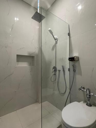 a bathroom with a glass shower with a toilet at Kawa Living in Krukah