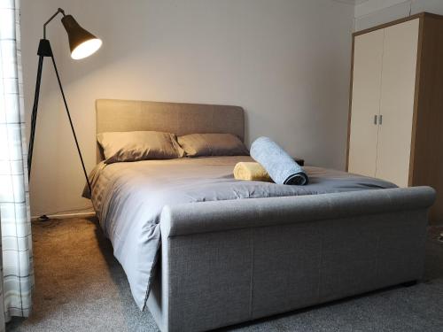 uma cama num quarto com um candeeiro e uma cama com uma almofada em White House "Luton Airport" em Luton