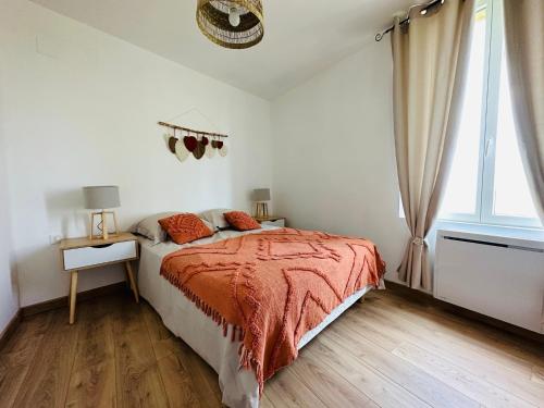 sypialnia z łóżkiem z pomarańczowym kocem i oknem w obiekcie La ferme de la brutellette w mieście Woignarue