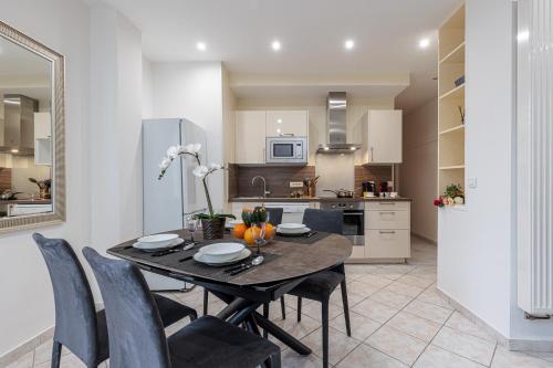 une cuisine et une salle à manger avec une table et des chaises dans l'établissement FEEL HOME - Congrès 13, à Nice