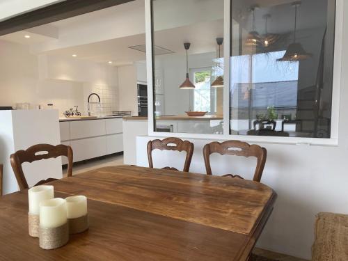 a kitchen with a wooden table and chairs in a kitchen at Villa Vieilles Vignes vue mer in Billiers