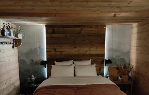 a bedroom with a large bed with wooden walls at Chambre Trèfle in Entremont