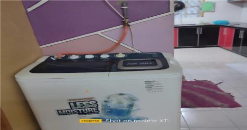 aines microwave on top of a box in a kitchen at Homestay Tengku Maheran in Jitra