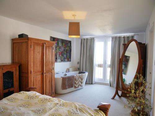 a bedroom with a bed and a mirror and a tub at Close to beaches and town, off street parking in Kent