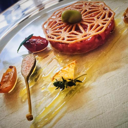 a plate with a waffle with a green olive on it at Boutique Hotel Masseria Sottomasi in Savelletri di Fasano