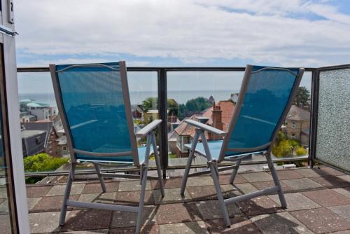 Duas cadeiras sentadas em cima de uma varanda em The Riviera Hotel & Apartments - Alum Chine em Bournemouth