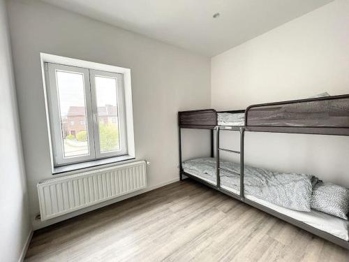 une chambre avec deux lits superposés et une fenêtre dans l'établissement Wauters 75 Bruxelles-charleroi-airport, à Charleroi