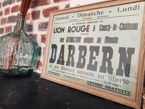 a glass vase sitting on a table next to a sign at Domaine du lion rouge Piscine et Spa in Coucy-le-Château-Auffrique