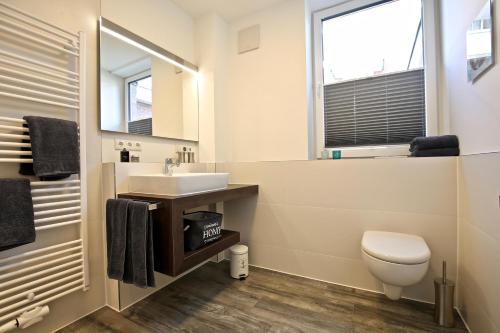 a bathroom with a sink and a toilet and a window at Villa Petersen Ankerplatz 3 in Wangerooge