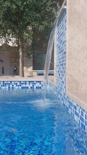 a water fountain in a pool with blue tiles at Apartments Sutorina in Herceg-Novi