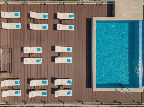a swimming pool next to a brown wall at Garni Hotel Kruso in Herceg-Novi