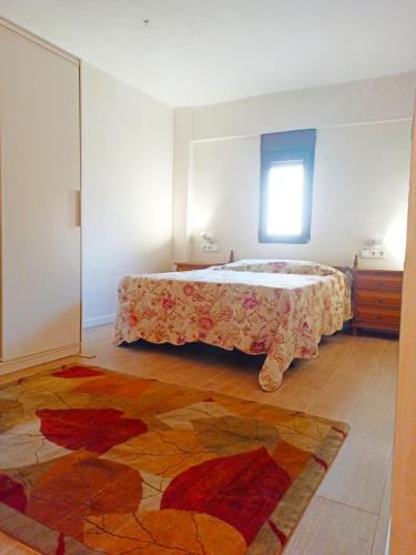 una camera con un letto e un tappeto sul pavimento di Vistas a las palmeras a Burjassot