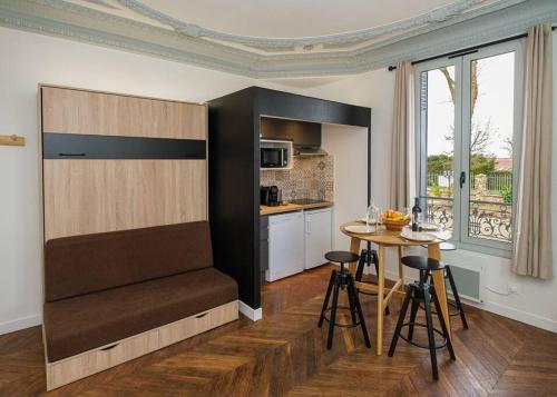 une cuisine avec une table et une cuisine avec une salle à manger dans l'établissement Villa Forestière Studio Le Châtaignier, à Quincy-Voisins