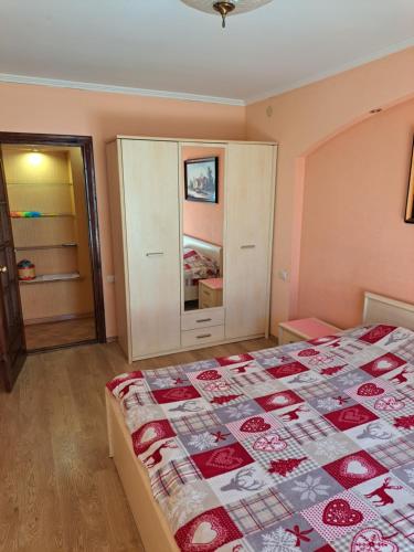1 dormitorio con 1 cama con edredón rojo y blanco en Квартира в центрі на Волі 8 en Lutsʼk