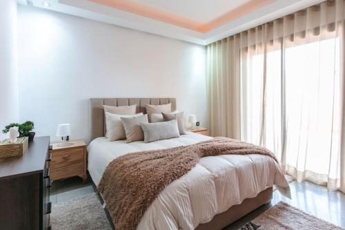 a bedroom with a large bed and a large window at Elite Escape - Marrakech Centre in Marrakech
