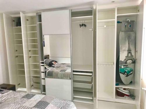 - une chambre avec des placards blancs, un lit et un miroir dans l'établissement maison vieux Lille, à Lille