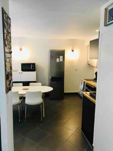 une cuisine avec une table, des chaises et un réfrigérateur dans l'établissement maison vieux Lille, à Lille