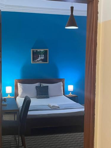 a blue bedroom with a bed with a blue wall at Les 5 lanternes by Clara in Dakar