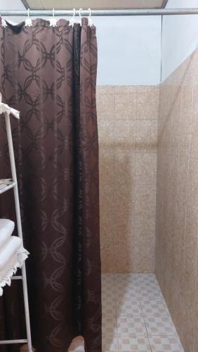 y baño con ducha con cortina marrón. en Tocumen Sweet Home, en Cabuya