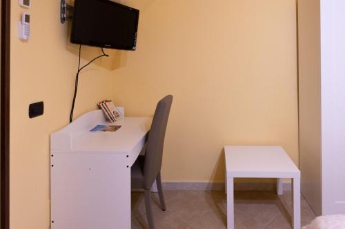 a white desk with a chair and a tv on a wall at La casa di Alice in Cisternino
