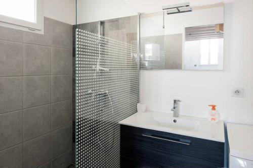 une salle de bain avec un lavabo et une douche avec un miroir dans l'établissement Superbe T1 bis de 35 m2 - stationnement gratuit - proche gare et port - Apt Droit, à La Rochelle