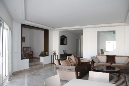 sala de estar con sofás y mesa en Chambres d'hôtes Conviviales avec piscine privée Chambre Namasté et Chambre Rose des Sables, en Djerba