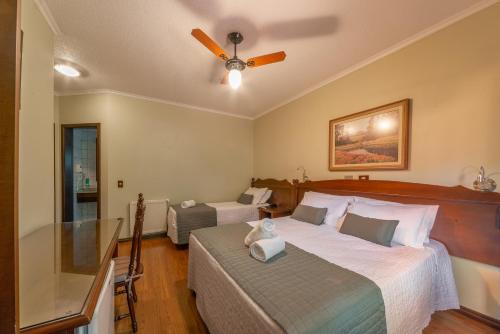 a bedroom with two beds and a ceiling fan at Pousada Monte Felice Recanto da Lua in Gramado