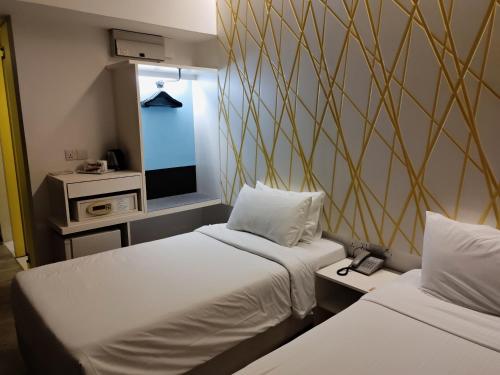 um quarto com duas camas e uma televisão em Comfy Room In Genting Highlands em Genting Highlands