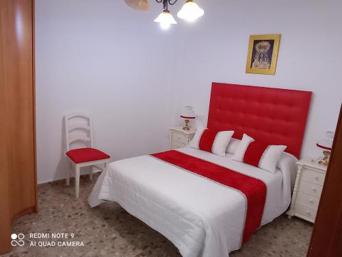 a bedroom with a large bed with a red headboard at habitación roja in Barbate